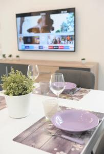 a table with two wine glasses and a tv at 2 Camere 50m dal Mare e Parcheggio Privato in Marina di Pietrasanta