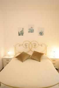 a bedroom with a white bed with two pillows at 2 Camere 50m dal Mare e Parcheggio Privato in Marina di Pietrasanta