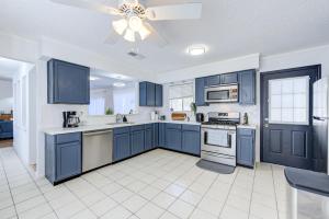 a kitchen with blue cabinets and a ceiling fan at Cozy 3 bedrooms home with indoor fireplace in Houston