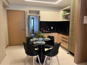 a black dining room table with black chairs in a kitchen at Apto moderno com vista para o mar da Jatiúca in Maceió