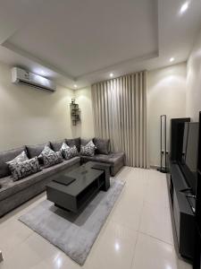 a living room with a couch and a tv at Zaan Apartment Al-Nafel in Riyadh