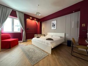 um quarto com uma cama branca e uma parede vermelha em Art’n’ shelter apartament em Bari