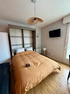 a bedroom with a bed and a flat screen tv at Appartement au pied de la Dune et Parking privé in Berck-sur-Mer