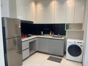 a kitchen with a refrigerator and a washing machine at Opus Residence Kuala Lumpur by BJM in Kuala Lumpur