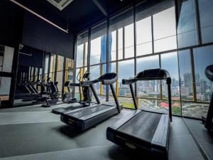 a gym with cardio equipment in a building with windows at Opus Residence Kuala Lumpur by KL Suite in Kuala Lumpur