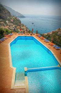a large swimming pool with a view of the ocean at Villa De Simone in Positano