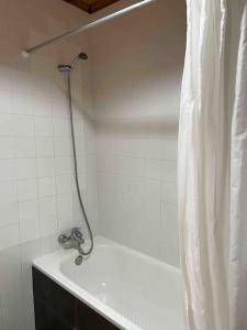 a shower in a bathroom with a white shower curtain at Casa do Cacto - 1 Bedroom Cosy Flat in Madalena