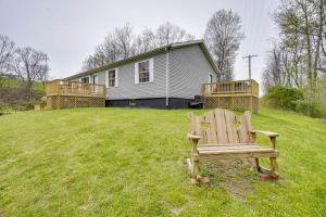 un banc en bois assis dans l'herbe devant une maison dans l'établissement Pet-Friendly Zanesville Haven with Game Room!, à Zanesville