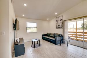 a living room with a black leather couch and a table at Tampa Sanctuary Near Airport and Sports Venues! in Tampa