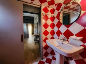 baño con pared de cuadros rojo y blanco en Μέντα 1, en Kalamata