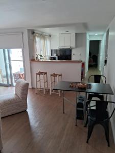 a living room and kitchen with a table and chairs at DEPARTAMENTO JARDIN in Santiago del Estero