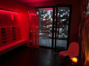 une chambre rouge avec une chaise et une table dans l'établissement Axel Boutique Jacuzzi & Sauna, à Dziwnów