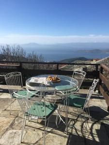een tafel en stoelen op een balkon met uitzicht bij Pelion country house in Volos
