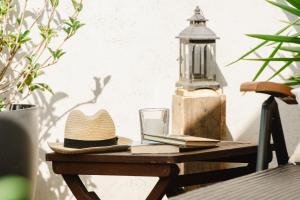 Un sombrero y libros sobre una mesa de madera. en Ca La Gracieta, en Santa Cristina d'Aro