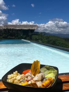 a bowl of food in front of a swimming pool at El Resort de Yanashpa - Tarapoto in Tarapoto