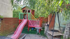 un parque infantil con tobogán y una casa de juegos en Helios, en Mielno