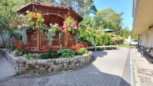 a gazebo with flowers on it next to a sidewalk at Helios in Mielno