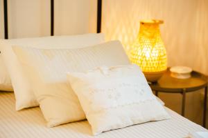 Una cama con dos almohadas y una mesa con un jarrón. en Ca La Gracieta, en Santa Cristina d'Aro