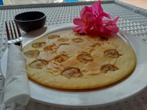 una pizza su un piatto con un fiore sopra di Lumiere Hotel Gili Trawangan a Gili Trawangan