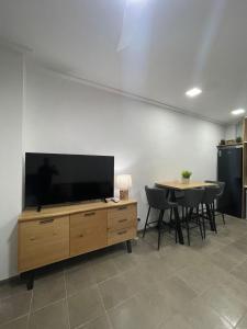 a living room with a flat screen tv and a table at UIM Mediterraneo Estudio PB San Jose Wifi in Puerto de Sagunto +2 photos