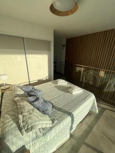 1 dormitorio con cama, lámpara y ventana en Miras Apartment Ushuaia en Ushuaia