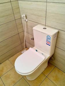 uma casa de banho com um WC com um cabo ligado à parede em Honeycomb em Ukonga