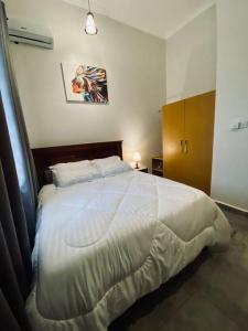 um quarto com uma grande cama branca num quarto em Honeycomb em Ukonga
