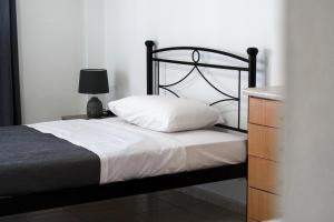 1 dormitorio con cama, lámpara y cómoda en Blue Sea Apartment, en Adelianos Kampos