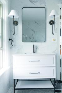 uma casa de banho com um lavatório branco e um espelho. em Inn of Chagrin em Chagrin Falls