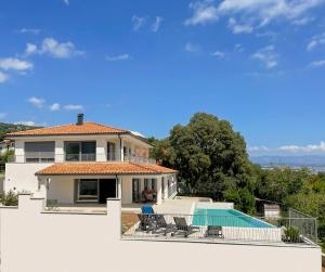 eine Villa mit einem Pool und einem Haus in der Unterkunft Villa Maritima-Meerblick-Infinity Pool-Luxus-Relax in Poljane