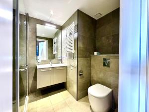 a bathroom with a toilet and a sink at Sunshine Apartments Batumi Lux in Batumi