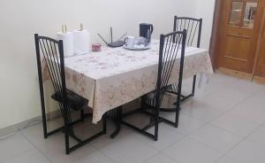 une table avec deux chaises et une table avec un tissu de table blanc dans l'établissement AMDI Appartement, à Dakar 3 autres photos