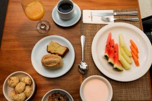 a wooden table with plates of food and a drink at Intercity São Paulo Ibirapuera in São Paulo