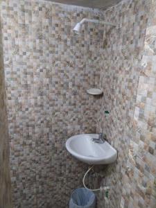 baño con lavabo en una pared de azulejos en Hostal #10-33 en Cartagena de Indias