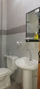 une salle de bains blanche avec toilettes et lavabo dans l'établissement AMDI Appartement, à Dakar