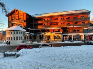 un grand bâtiment avec des voitures garées dans la neige dans l'établissement Beau 2 pièces, au pied des pistes Résidence Adonis, à Valberg