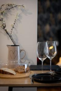 羅亞爾河畔普伊的住宿－Romance dans les vignes，一张桌子,上面放着两杯酒和一盘食物