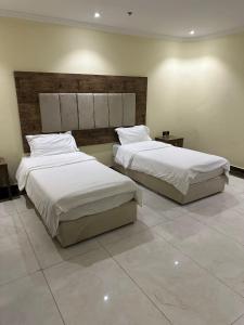 كيان حراء للشقق المخدومة- Kayan Hiraa Serviced Apartments في جدة: سريرين في غرفة الفندق ذات شراشف بيضاء