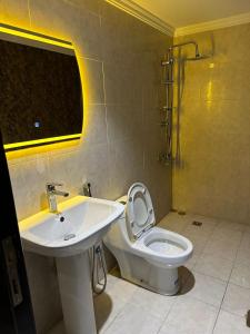 a bathroom with a white toilet and a sink at كيان حراء للشقق المخدومة- Kayan Hiraa Serviced Apartments in Jeddah