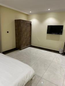 a bedroom with a bed and a flat screen tv at كيان حراء للشقق المخدومة- Kayan Hiraa Serviced Apartments in Jeddah