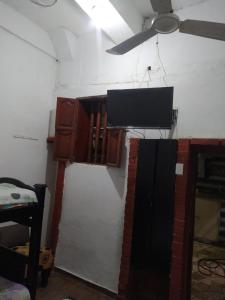 TV en la pared de una habitación en Hostal #10-33 en Cartagena de Indias