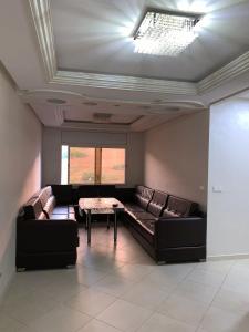 un soggiorno con divano e tavolo di Apartamentos Palace Rif Al Hoceima ad Al-Ḥoseyma