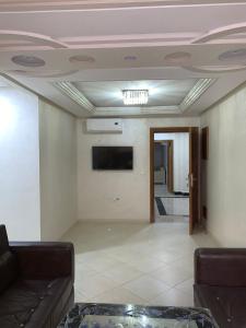 Apartamentos Palace Rif Al Hoceima في الحسيمة: غرفة معيشة مع أريكة وتلفزيون على السقف