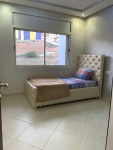 Apartamentos Palace Rif Al Hoceima في الحسيمة: سرير في غرفة مع نافذة