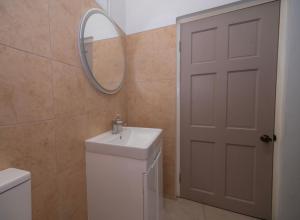Un baño con un lavabo blanco y un espejo. en SOHI Villa, en Gros Islet