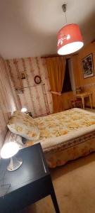 a bedroom with a bed and a red lamp at En pleine nature cantalienne et au calme village , Maison confortable et spacieuse pour 9 pers in Vezels-Roussy