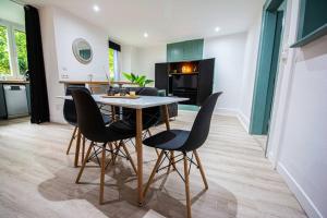 cocina y sala de estar con mesa y sillas en La Feuille Dorée, au calme, parking gratuit, en Belfort