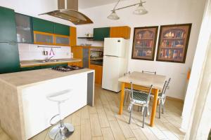 eine Küche mit einem Tisch und einem weißen Kühlschrank in der Unterkunft Sunset House in Matino