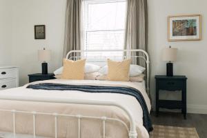 a bedroom with a white bed with pillows and a window at Waterfront Cottage w Sauna on Sharbot Lake in Sharbot Lake