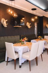 a dining room with a table and white chairs at Hotel Punta Arena Spa Boutique in Arauca